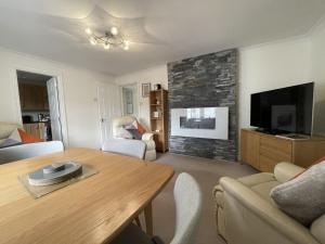 a living room with a table and a flat screen tv at Maiden Moor in Keswick