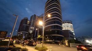 a city street with cars parked in front of a tall building at Pacific Towers Star Seksyen 13 PJ Jaya One Parking Netflix Pool Kitchen in Petaling Jaya