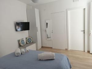 a white room with a bed with a tv on the wall at Casa dei mulini in Favignana