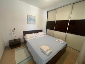 a bedroom with a bed with two towels on it at Apartments Andrea in Stara Novalja