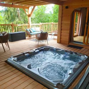 a hot tub on the deck of a cabin at Le château des fées in Illoud