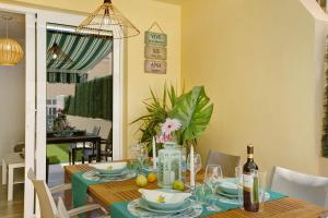 a dining room with a table with a green table cloth at Bungalow Sonemar Sunshine in Maspalomas