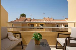 a balcony with a couch and a table and a building at Bungalow Sonemar Sunshine in Maspalomas