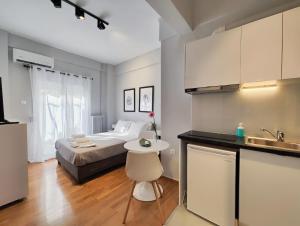 een slaapkamer met een bed en een keuken met een wastafel bij Zea Apartments in Piraeus