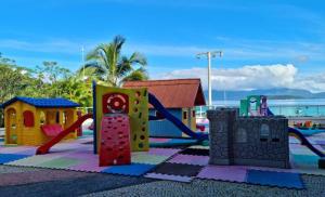 Un parque infantil con un tobogán y una estructura de juego. en Angra Inn - Praia Grande 318, en Angra dos Reis