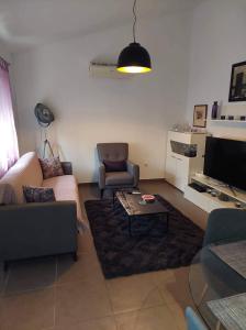 ein Wohnzimmer mit einem Sofa, einem Stuhl und einem TV in der Unterkunft Happy house in Split