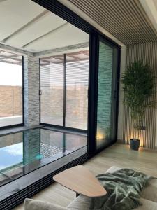 AB Villa في عجمان: غرفة معيشة مع نافذة كبيرة وطاولة