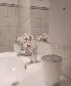 un lavabo con flores rosas encima en Apartman Sutivan, en Sutivan