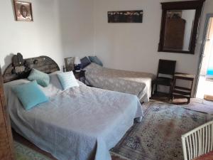 een slaapkamer met 2 bedden en een stoel bij LE PRIEURE in Saint-Florent-sur-Auzonnet