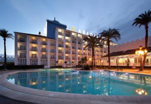 a hotel with a large swimming pool at night at Hotel Abades Benacazon in Benacazón