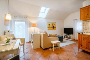 a living room with a couch and a tv at Gulfhof Butendiek - Ferienapartments in Neuharlingersiel