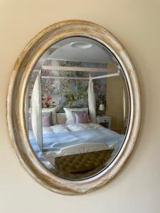 a mirror hanging on a wall with a bed at REFUGIUM Theresienstraße 19 - Chambre Morisot in Rhodt unter Rietburg