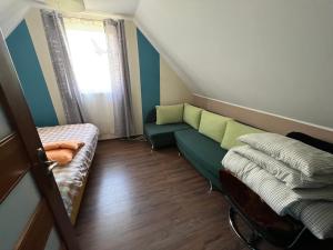 a small room with a green couch and a window at Kaszuby- Domek całoroczny nad Jeziorem Gowidlińskim in Sulęczyno