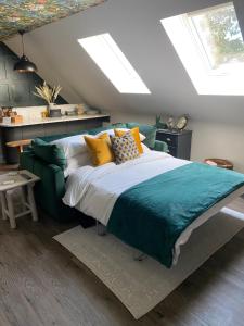 um quarto com uma cama grande e uma clarabóia em Stylish one bedroom Cotswold Coach House Tetbury em Tetbury