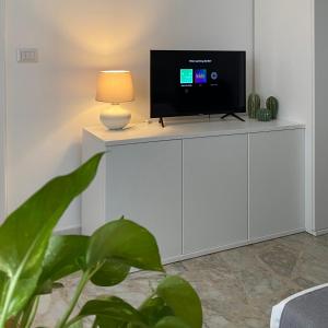 a tv on a white cabinet in a room with a lamp at Casa Vita Scilla in Scilla