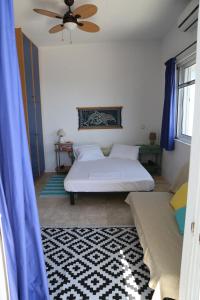 a bedroom with two beds and a ceiling fan at Sunrise seahouse in Vromopoúsi