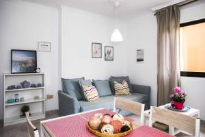 ein Wohnzimmer mit einem Sofa und einem Tisch in der Unterkunft Confortable vivienda en La Laguna a 5 MIN tranvía in La Laguna