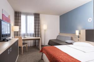 a hotel room with a bed and a television at Mercure Bonn Hardtberg in Bonn