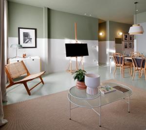 un soggiorno con tavolo, sedie e TV di Apartamento diseño Galiana 6 Avilés Asturias ad Avilés