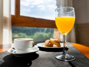 um copo de sumo de laranja ao lado de um prato de comida em Hotel Xauen em Montanejos