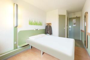 DéolsにあるB&B HOTEL Châteauroux A20 L'Occitaneの白いベッドと鏡が備わる客室です。