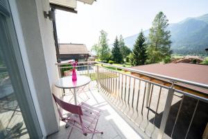 einen Balkon mit einem Tisch und 2 Stühlen darauf in der Unterkunft Villa Hubertus Enzian in Kirchbach