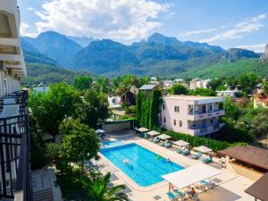 a view of a resort with a swimming pool and mountains at Tal Beach Hotel in Beldibi