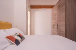 1 dormitorio con cama blanca y armario de madera en Centrale Mazzoni Apartments R&R, en Venecia
