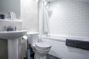 La salle de bains blanche est pourvue de toilettes et d'un lavabo. dans l'établissement Wern Y Glais - 2 Bedroom Cottage - Glais, à Swansea