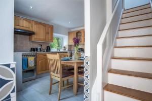 a kitchen with a wooden table and a staircase at Wern Y Glais - 2 Bedroom Cottage - Glais in Swansea