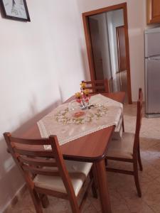 a dining room table with a table cloth and flowers on it at Home in Vlorë