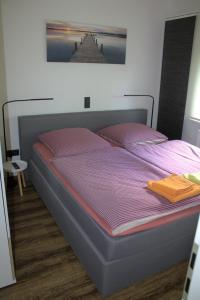 a bedroom with a bed with a purple comforter at Ferienhaus Bergliebe in Willingen in Willingen