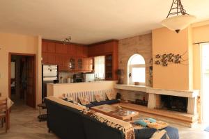 a living room with a couch and a fireplace at Sunrise seahouse in Vromopoúsi +21 photos