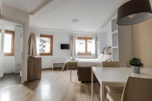 - une chambre avec un lit et une table dans l'établissement Outdoor Apartaments - Basecamp, à Andorre-la-Vieille