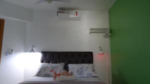 um quarto com uma cama com uma cabeceira e almofadas pretas em Belíssimo Apto à Beira Mar em Arraial do Cabo