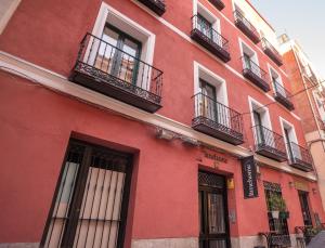 czerwony budynek z oknami i balkonami w obiekcie limehome Madrid Calle de Fomento - estancia temporal w Madrycie +37 zdjęć