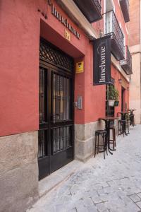 limehome Madrid Calle de Fomento - Digital Access في مدريد: مبنى احمر وباب اسود وطاولة بالخارج