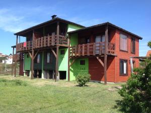 a wooden house with balconies on the side of it at Complejo La Pausa in Punta Del Diablo