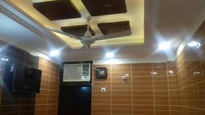 a bathroom with a ceiling with a fan and brown tiles at Posh, Nice Foreigner Area Lajpat Ngar Luxury Room in New Delhi