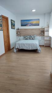 a bedroom with a bed and a wooden floor at Carihuela Playa 1 in Torremolinos