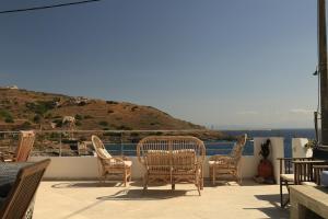 a group of chairs and a table on a balcony at Sunrise seahouse in Vromopoúsi