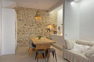 ein Wohnzimmer mit einem Tisch und einem Sofa in der Unterkunft Luxe 8P dorpshuis centrum l'Escala 50m van strand in L'Escala