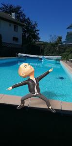 a figurine of a person sitting in front of a swimming pool at Le domaine de shania in Provenchères-sur-Fave