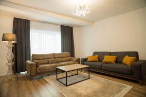 - un salon avec un canapé et une table dans l'établissement Lux Apartments, à Pristina