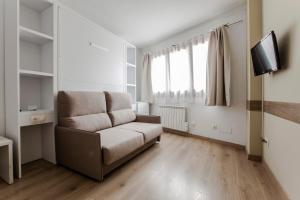 uma sala de estar com um sofá e uma televisão em Outdoor Apartaments - Basecamp em Andorra-a-Velha