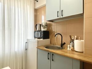 a small kitchen with a sink and a microwave at Apart.Boutique B. Mangalia in Mangalia