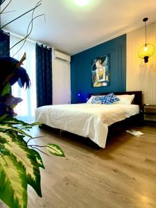 a bedroom with a bed with a blue wall at Apart.Boutique B. Mangalia in Mangalia