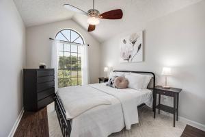 a bedroom with a bed with a ceiling fan and a window at Bermuda Drive Abode in Fleming Island