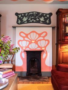 una sala de estar con chimenea y obras de arte negro y naranja en la pared en Sawcliffe Manor Country House with Spa, Free Parking, Catering, Self Checkin, Farmstay, en Scunthorpe 228 fotos más