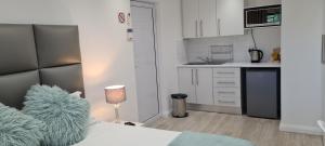 1 dormitorio con 1 cama y cocina pequeña en Mossel 11 Studio, en Bloubergstrand